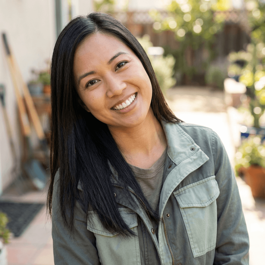 Sarah Mitchell smiling in her backyard with landscape plans